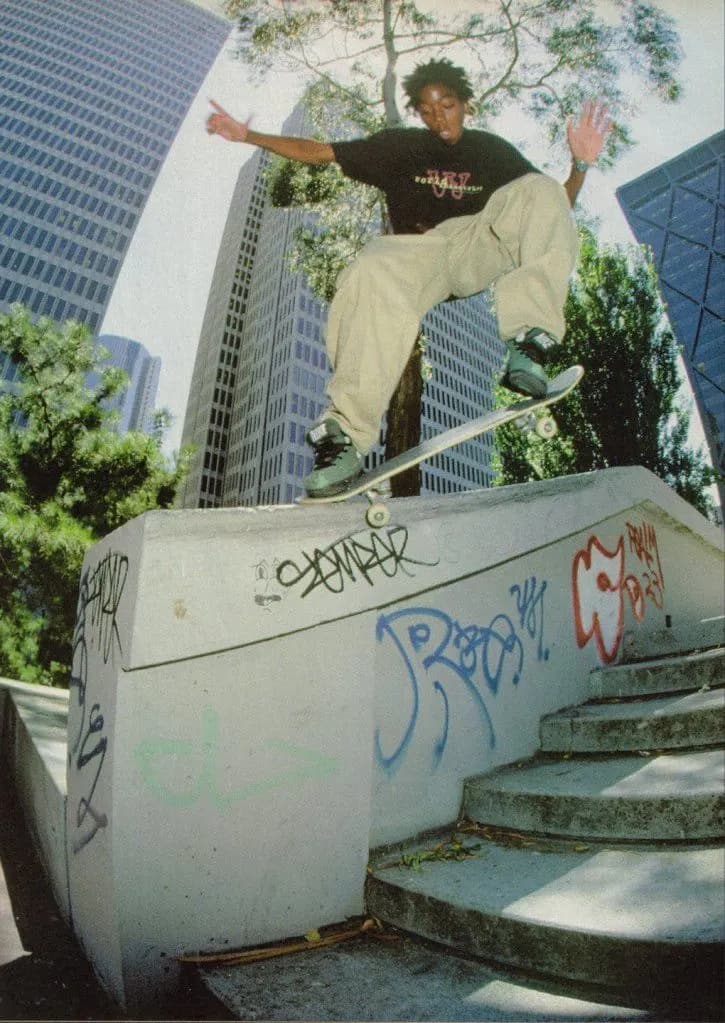 Skateur en plein grind sur un spot urbain, style magazine 90s.