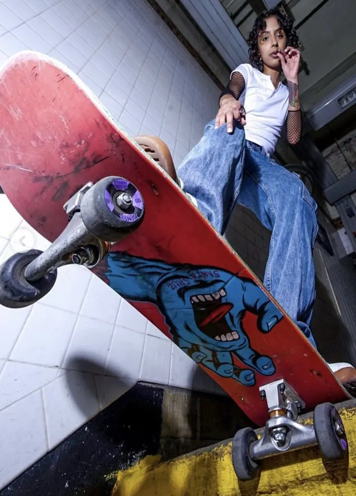 Skateuse en contre-plongée avec une planche Screaming Hand.