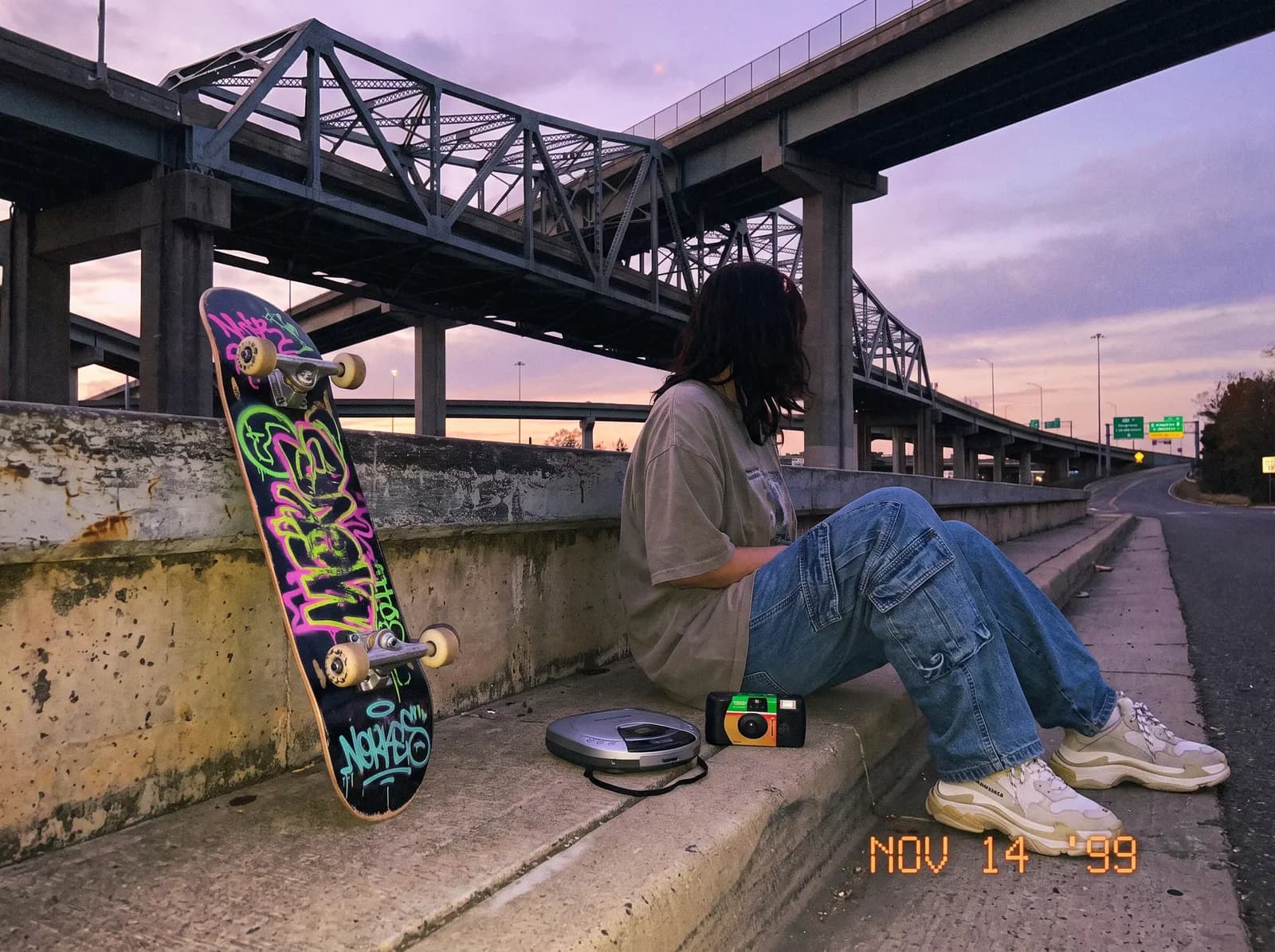 Skateuse assise sous un pont au coucher de soleil, ambiance 99.